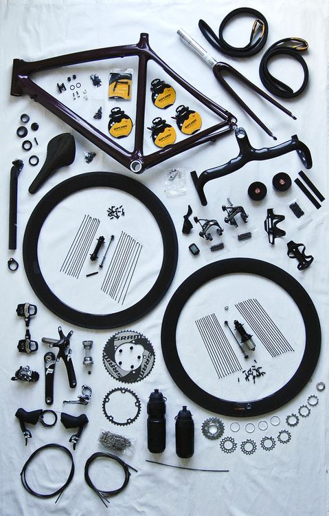Disassembled bicycle with components laid out neatly.